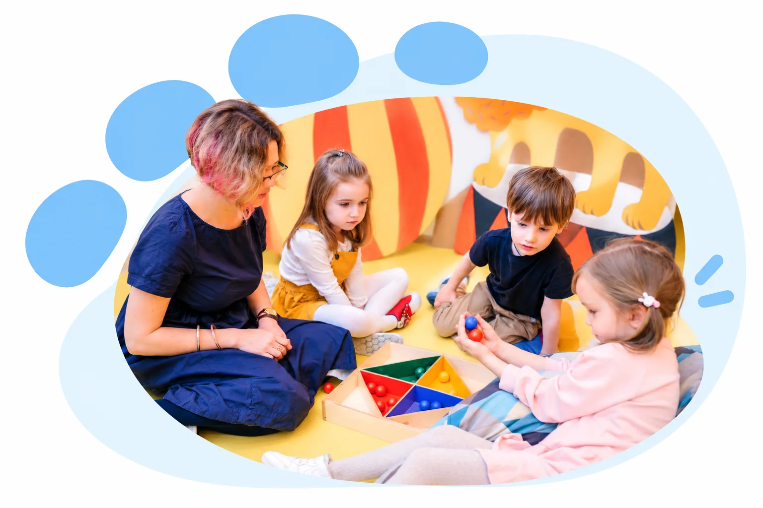 Una adulta y tres niños participan en una actividad con materiales de colores, en una composición con huella celeste.