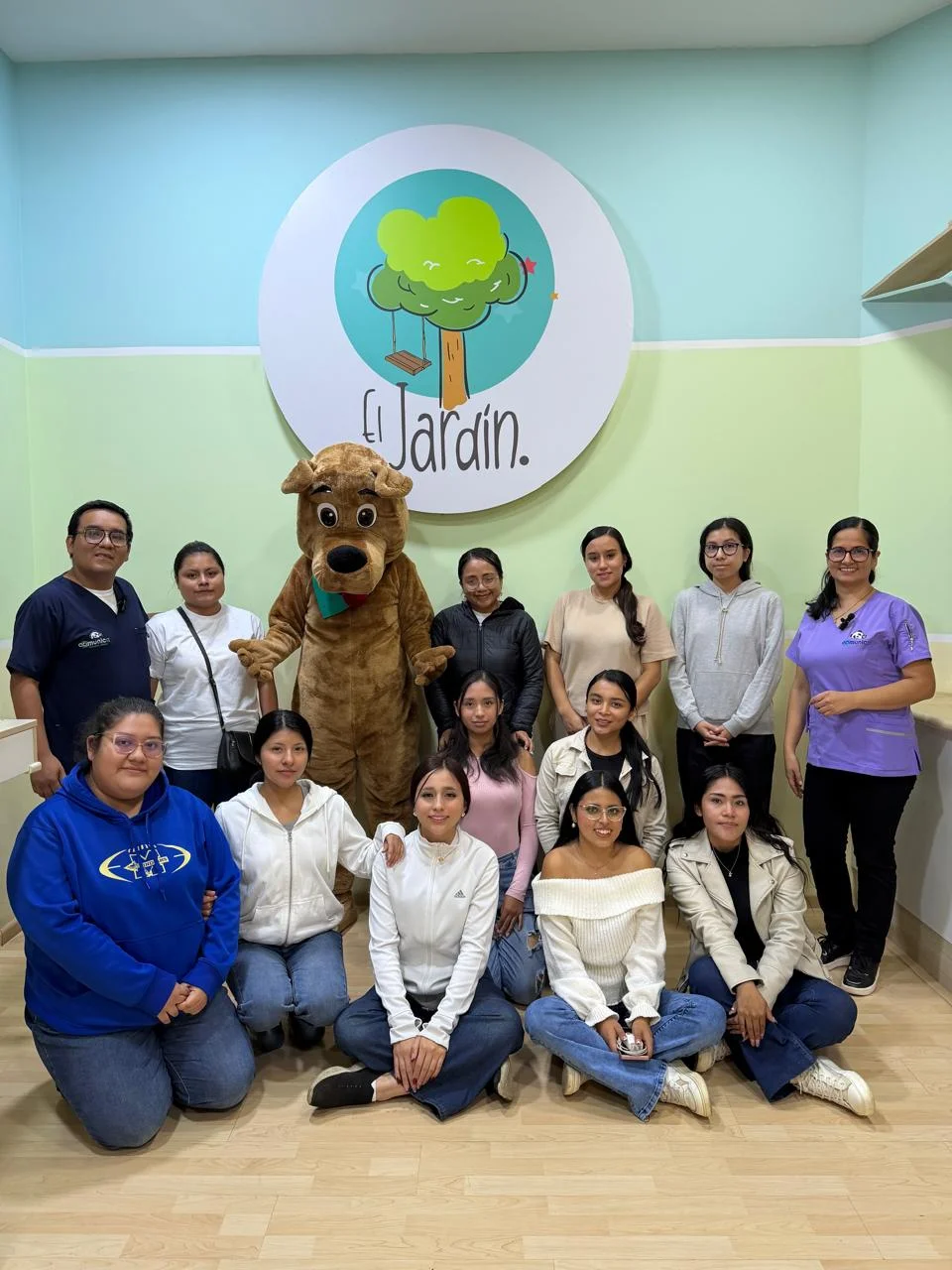 Participantes de un encuentro grupal frente al logotipo de El Jardín.